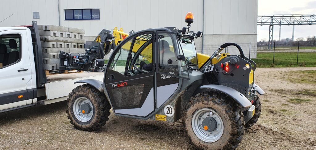 Einsatz abladen Bauazun Betonfüsse von LKW Mietmaschine ein Wacker Neuson Teleskoplader TH627 Einsatz abladen Bauazun Betonfüsse von LKW Mietmaschine ein Wacker Neuson Teleskoplader TH627