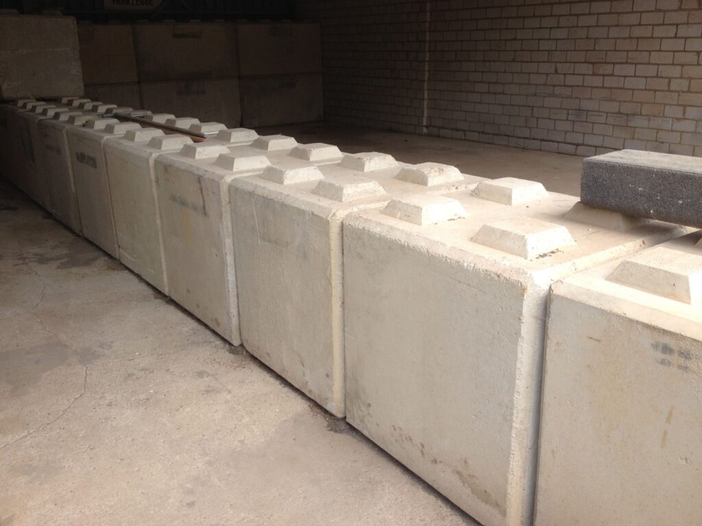 Sichtbeton gestalten: Strukturmatrizen revolutionieren die moderne Betontechnik 5 Betonkloetze massiv Halle Lager Sichtbeton steht heute für mehr als nur rohe Ästhetik – er vereint Tragfähigkeit mit anspruchsvollem Design. Durch den gezielten Einsatz von Strukturmatrizen lassen sich Betonoberflächen mit Mustern, Texturen und Reliefs gestalten, die sowohl optisch beeindrucken und funktional überzeugen. Besonders im Hochbau, bei Fassaden, Brücken oder im Innenausbau setzen Planer auf diese innovative Technik. Die gestalterischen Möglichkeiten reichen von minimalistisch-reduzierten Strukturen bis hin zu aufwendigen Ornamenten – direkt ab Werk, ohne spätere Bearbeitung. So entsteht ein homogener, dauerhafter und ausdrucksstarker Baustoff, der Technik und Architektur auf einzigartige Weise miteinander verbindet.