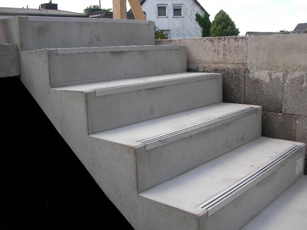Sichtbeton gestalten: Strukturmatrizen revolutionieren die moderne Betontechnik 2 Bild Foto Treppe Aus Betonfertigteilen Hier Hin Zum Oberschoss 2 Sichtbeton steht heute für mehr als nur rohe Ästhetik – er vereint Tragfähigkeit mit anspruchsvollem Design. Durch den gezielten Einsatz von Strukturmatrizen lassen sich Betonoberflächen mit Mustern, Texturen und Reliefs gestalten, die sowohl optisch beeindrucken und funktional überzeugen. Besonders im Hochbau, bei Fassaden, Brücken oder im Innenausbau setzen Planer auf diese innovative Technik. Die gestalterischen Möglichkeiten reichen von minimalistisch-reduzierten Strukturen bis hin zu aufwendigen Ornamenten – direkt ab Werk, ohne spätere Bearbeitung. So entsteht ein homogener, dauerhafter und ausdrucksstarker Baustoff, der Technik und Architektur auf einzigartige Weise miteinander verbindet.